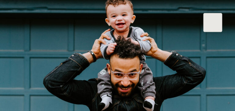 Thumbnail of man holding his toddler on his shoulders.