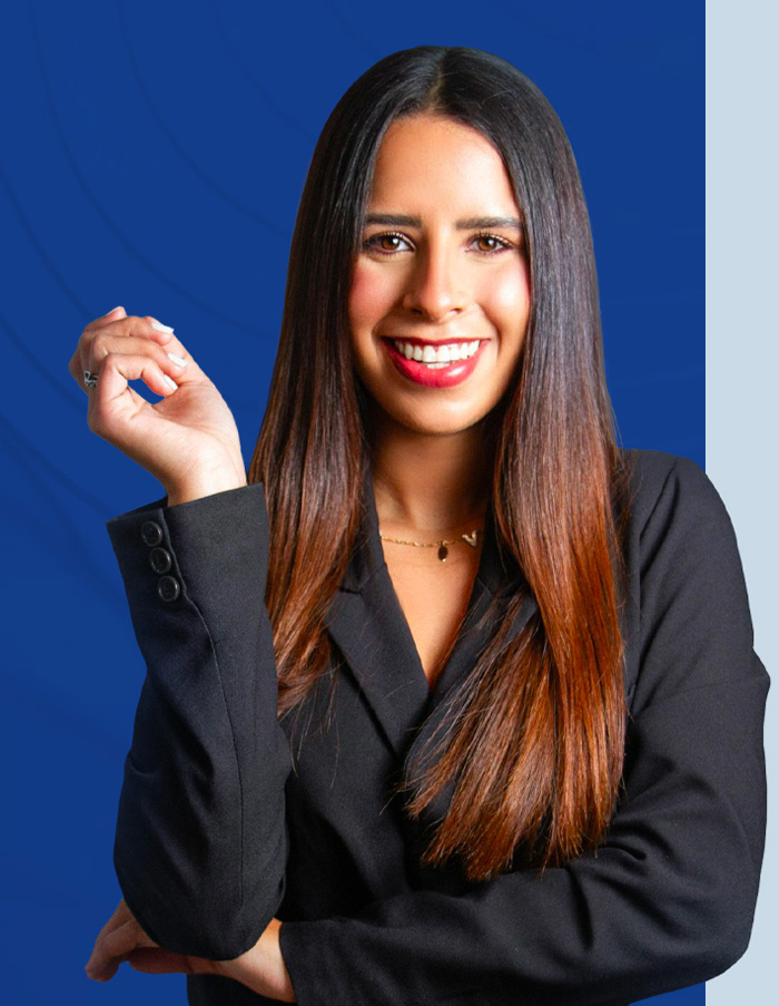 Su agente de seguros! Mujer sonriente vestida de negro y con los brazos cruzados, frente a un rectángulo azul. Your insurance agent! Smiling woman in black with arms crossed against a blue rectangle.