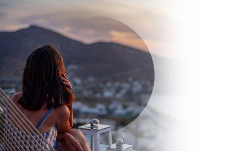 Life Insurance example. Img: Woman looks off into mountains and view of a town below.